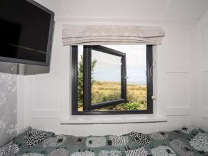 a window in a room with a bed and a television at Shepherds Stone in Holyhead