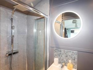 a bathroom with a shower and a sink and a mirror at Shepherds Stone in Holyhead