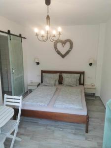 a bedroom with a bed with a heart on the wall at Zsálya Vendégház in Csopak