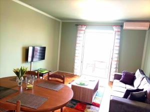 a living room with a table and a couch at Meeresblick Apartment S4 in Promajna