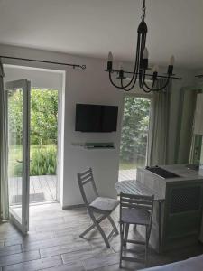 a living room with a table and chairs and a television at Zsálya Vendégház in Csopak +1 photo