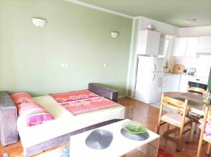a room with a bed and a table and a kitchen at Meeresblick Apartment S4 in Promajna