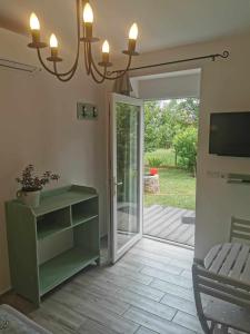 a living room with a green cabinet and a sliding glass door at Zsálya Vendégház in Csopak