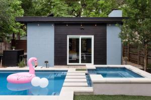 a house with a swimming pool with a pink flamingo at Pristine Pool Palace 6BR - Rainey St - 7min walk in Austin