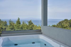 a bath tub with a view of the ocean at Mirabilia Boutique Hotel in Kriopigi