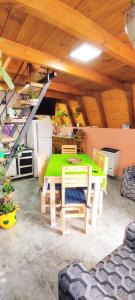 a dining room with a green table and chairs at Paluna cabaña in San Martín de los Andes