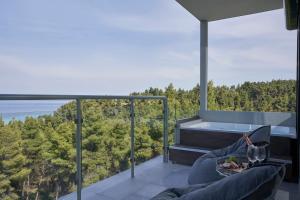 a balcony with a tub and a view of trees at Mirabilia Boutique Hotel in Kriopigi