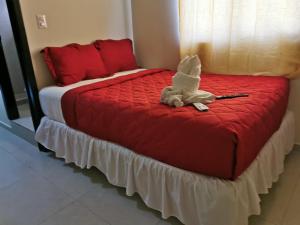 a bed with a stuffed animal sitting on top of it at Casa El Cipres Residencial Privada in Santo Tomás