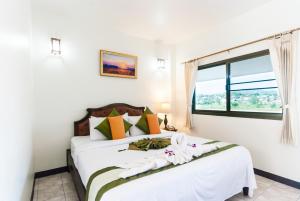 a bedroom with a white bed with a window at Namkhong Riverside in Chiang Khong