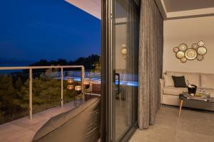 a balcony with a view of the ocean at night at Mirabilia Boutique Hotel in Kriopigi