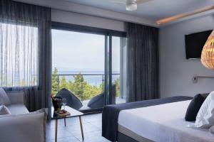 a hotel room with a bed and a large window at Mirabilia Boutique Hotel in Kriopigi