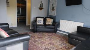 uma sala de estar com duas cadeiras e um sofá em Admirals Apartment sleeps 4 adults 2 children EV Point em Looe