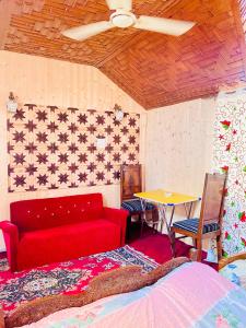 a living room with a red couch and a table at House Boat New Pala Palace in Srinagar