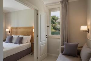 ein Schlafzimmer mit einem Bett und einem Fenster in der Unterkunft Borgopetra Resort Numana in Numana + 51 Fotos