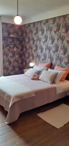 a bedroom with a large bed with a wall at Maison blanche in Cherval