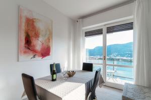 una sala da pranzo con tavolo e una grande finestra di Window flat - The House Of Travelers a Como