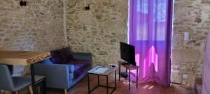 a living room with a couch and pink curtains at La cachette sarladaise in Sarlat-la-Canéda