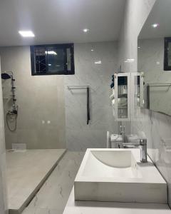 Notre Residence 27 في داكار: حمام أبيض مع حوض ودش