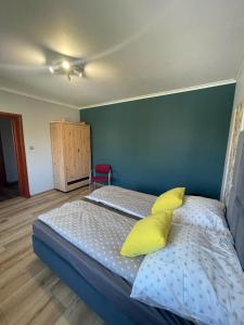 Un dormitorio con una cama con almohadas amarillas. en Apartament London, en Kielce