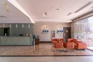 eine Lobby mit orangefarbenen Stühlen und einer Theke in einem Gebäude in der Unterkunft Your Luxurious 2BR Al Reem Escape at Mangrove Place in Abu Dhabi