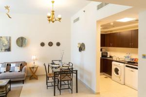 a kitchen and a living room with a table and chairs at Your Luxurious 2BR Al Reem Escape at Mangrove Place in Abu Dhabi