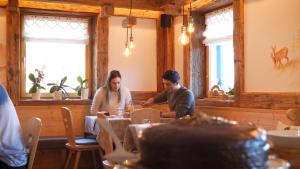 mężczyzna i kobieta siedzący przy stole w restauracji w obiekcie BB le Fontanelle w mieście Carano