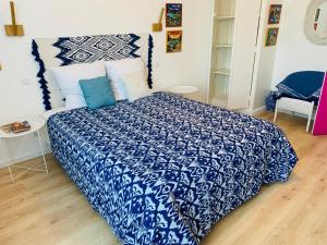 a bedroom with a bed with a blue and white comforter at Aux couleurs de Commarin in Commarin