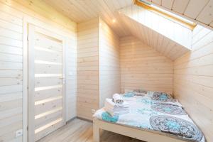 sauna z łóżkiem w drewnianym pokoju w obiekcie Domki Piaskowa11 Palm Resort & Wellness w Łebie