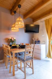 a dining room with a wooden table and chairs at Domki Piaskowa11 Palm Resort & Wellness in Łeba