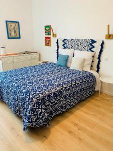 a bedroom with a bed with a blue and white comforter at Aux couleurs de Commarin in Commarin