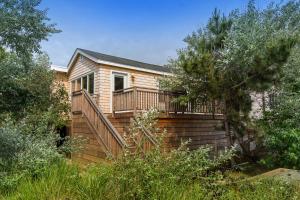 a house with a deck and stairs in a yard at Huron Hideaway in Ocean Bay Park