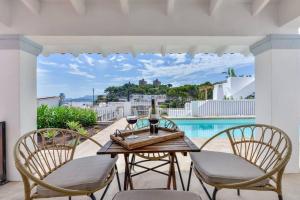 a patio with a table and chairs and a pool at Villas Guzman - San Vicente in Moraira