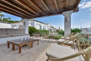 a patio with chairs and a couch and a table at Villas Guzman - San Vicente in Moraira