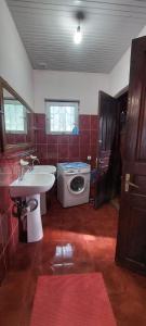 uma casa de banho com um lavatório e uma máquina de lavar roupa em Large house at the beach. em Grigoleti