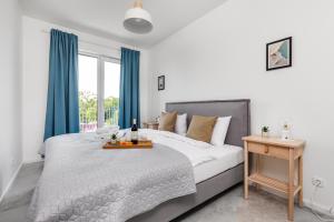 sypialnia z dużym łóżkiem z niebieskimi zasłonami w obiekcie Apartamenty Pilice w Jastrzębiej Górze