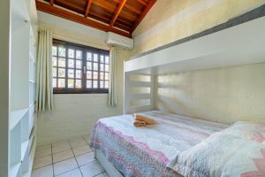 un dormitorio con una cama con un animal de peluche en Sobrado de Praia - 1 Quadra e Meia da Praia, para até 5 pessoas, en Bombinhas