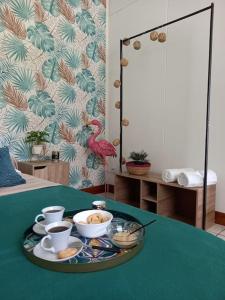 una mesa con una bandeja con tazas y cuencos. en ResaLoc - Maison Traditionnelle avec jardin en Saint-André