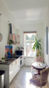 een keuken met een tafel, een wastafel en een raam bij Hotel Jugend with Self Check-in in Liepāja
