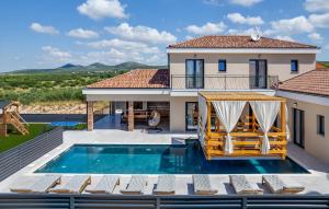 een villa met een zwembad en een huis bij Magnificent Villa Oasis with extra large pool in Vrana