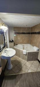 a bathroom with a bath tub and a sink at Days Inn by Wyndham Fort Wright Cincinnati Area in Fort Wright