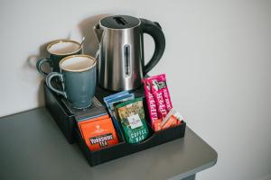 a shelf with books and coffee cups on a table at Miresfield Farm Bed & Breakfast in Malham