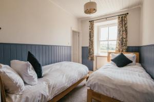 1 dormitorio con 2 camas y ventana en Miresfield Farm Bed & Breakfast en Malham