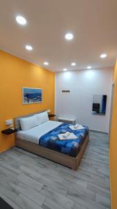 - une chambre avec un lit et une télévision murale dans l'établissement Giulia's House, à Naples
