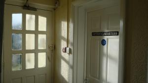 a door in a room with a sign next to it at Captain's Quarters parking for 1 car, EV point in Looe