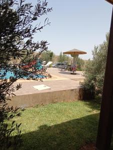 a patio with a picnic table and a umbrella at Ferme de Rayan in Safi