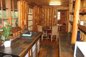 a kitchen in a log cabin with a table and chairs at On Golden Pond - Mount Amanzi in Hartbeespoort