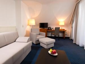 a living room with a white couch and a table at ACHAT Hotel Neustadt an der Weinstraße in Neustadt an der Weinstraße