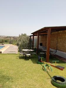 a pavilion with a table and chairs and a pool at Ferme de Rayan in Safi