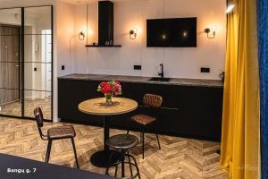 a kitchen with a table with a vase of flowers at No.1 Apartment Link-To-Happiness in Klaipėda