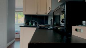 a kitchen with a black and white counter top at Captain's Quarters parking for 1 car, EV point in Looe